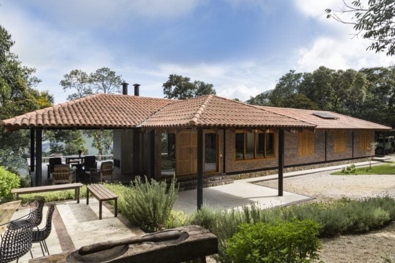Single-storey house with terracotta roof, brick walls, and covered patio with outdoor seating