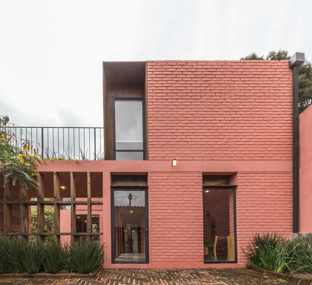 windows to the floor of a two-storey red brick house