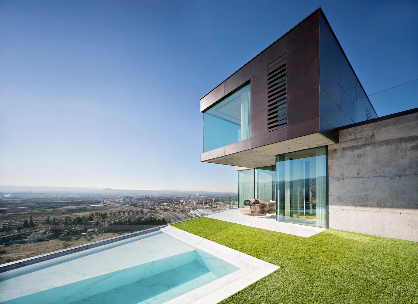 Concrete Walls Frame Panoramic Views in a Multi-Level Granada Home