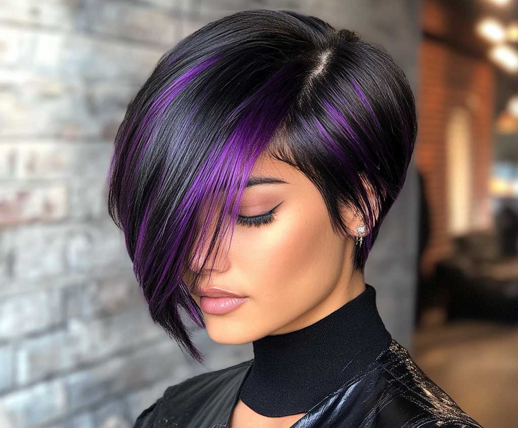 A close-up of a woman with a sleek long pixie haircut, featuring a jet black base color with subtle purple highlights woven throughout the layers. The hair is shiny and smooth, with the lighting highlighting the purple accents. The background is a minimalist urban setting, with soft lighting to enhance the sleekness of the hairstyle.