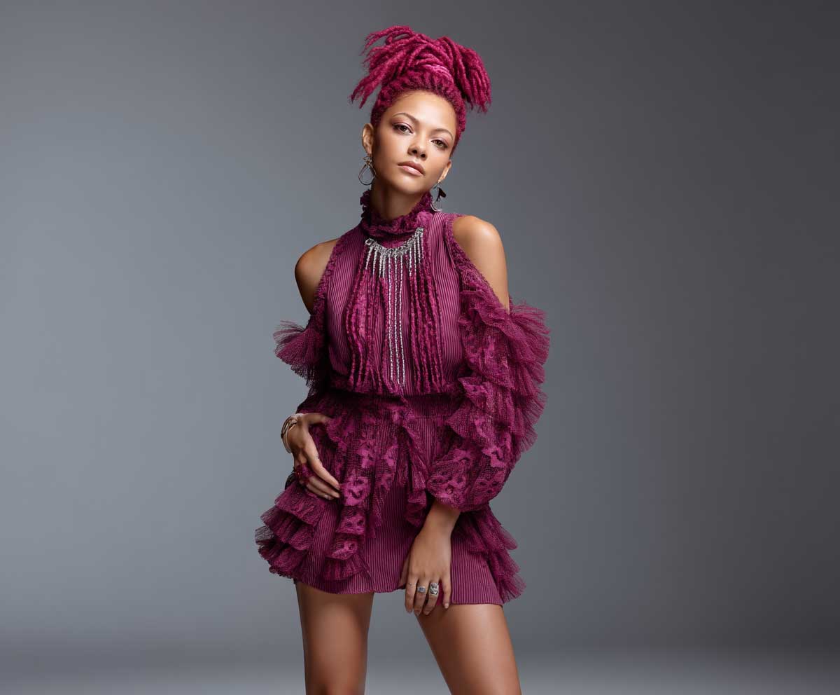full-length studio image of a confident woman with coarse magenta hair styled in crimped hairstyles, high ponytail with strong texture, fierce pose, high fashion look, bold lighting