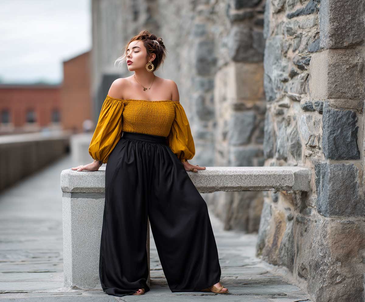 plus size woman in black palazzo pants and a mustard off shoulder top, leaning against a stone wall, urban backdrop, soft wind in hair, modern full body fashion photo, moody lighting