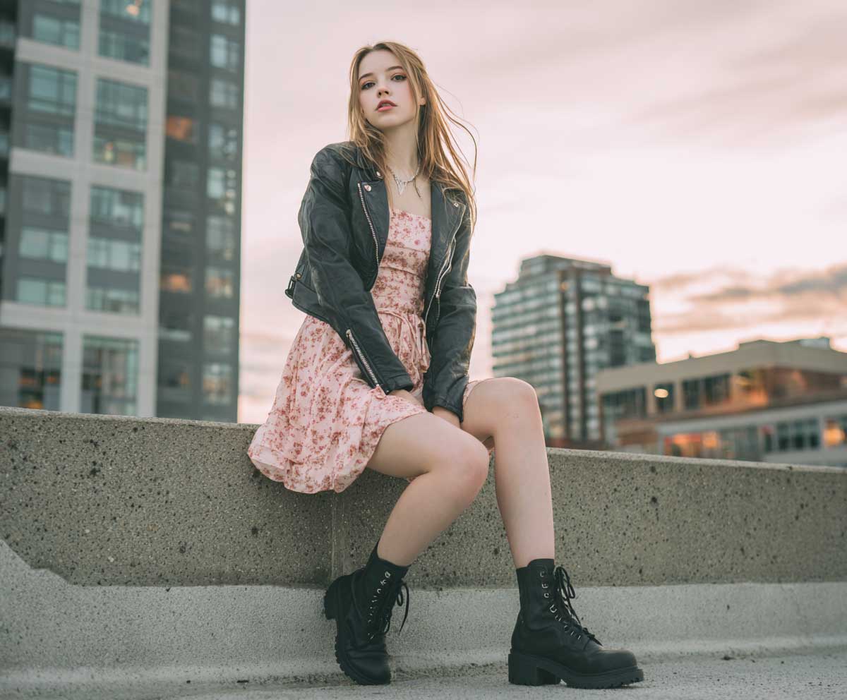 young woman in cropped leather jacket and pastel floral mini dress with black combat boots, urban backdrop, natural light, modern chic style, streetwear fashion vibe
