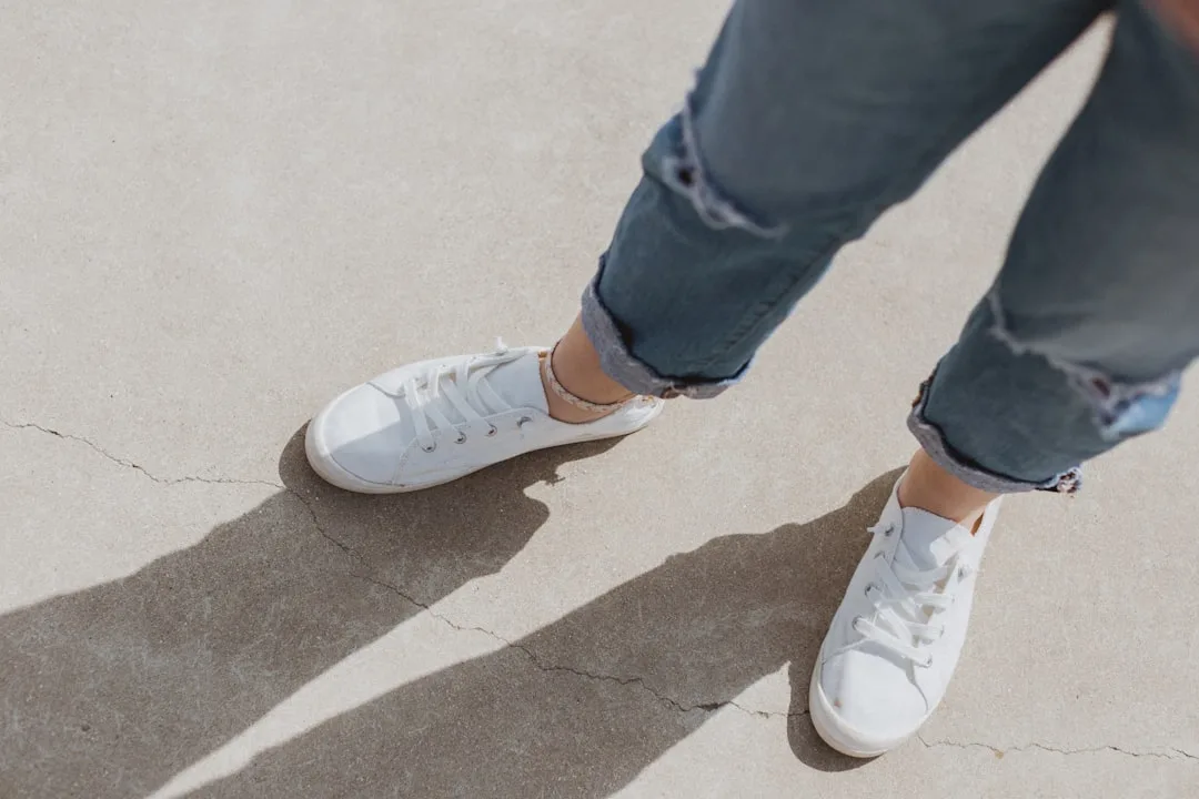 Cropped jeans styled with white sneakers and neutral top showing ankle length proportions detail 1