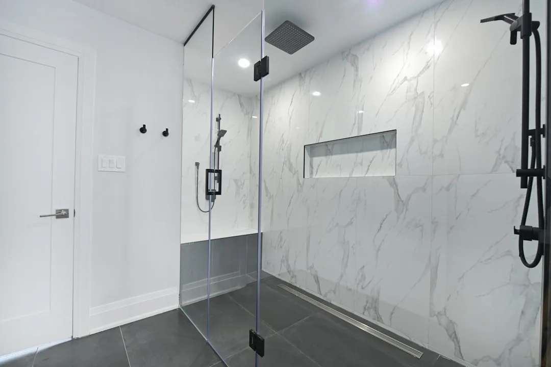 Wet room bathroom with linear drain system and polished concrete flooring
