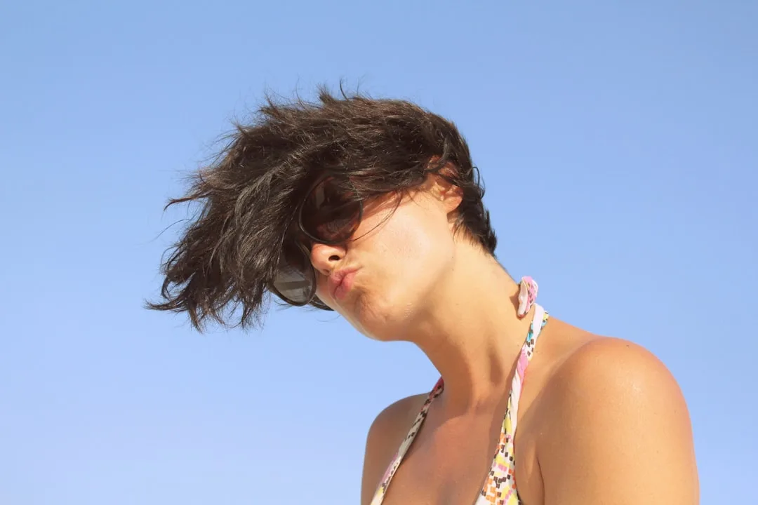 A woman in a bikini with her hair blowing in the wind