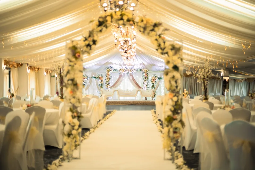 Tiered wedding reception lighting with warm Edison bulbs and uplighting
