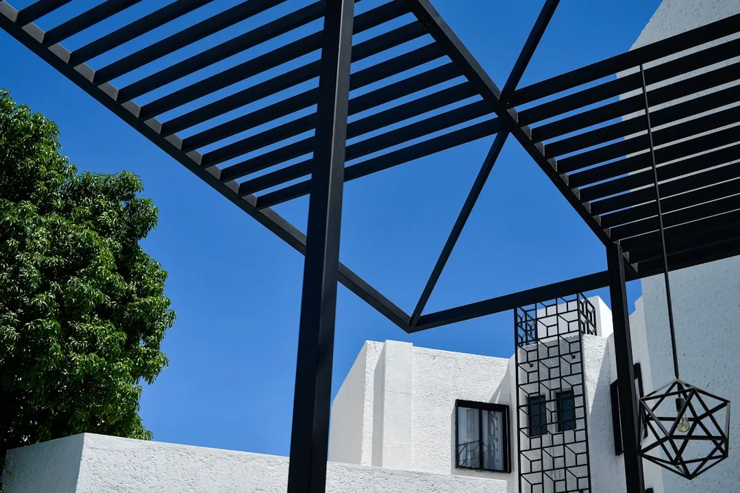 Retractable shade sail tensioned across modern backyard patio space