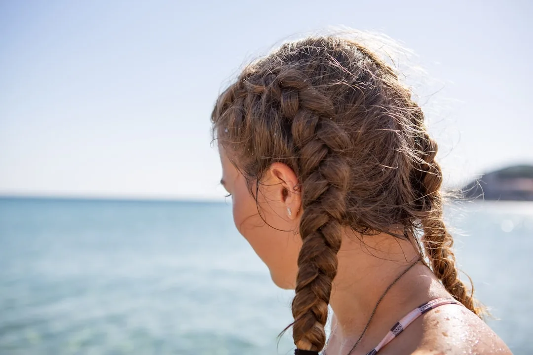 Close-up of Dutch braid technique on dark hair, sleek and polished finish