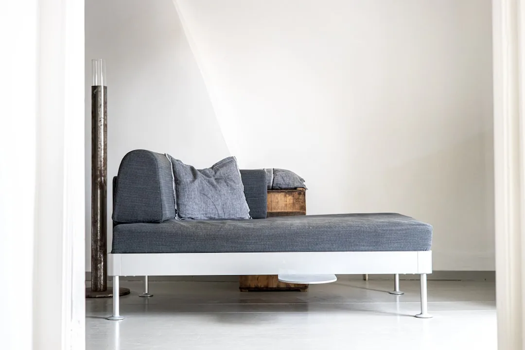 Close-up of Restoration Hardware teak daybed with linen cushions and side table