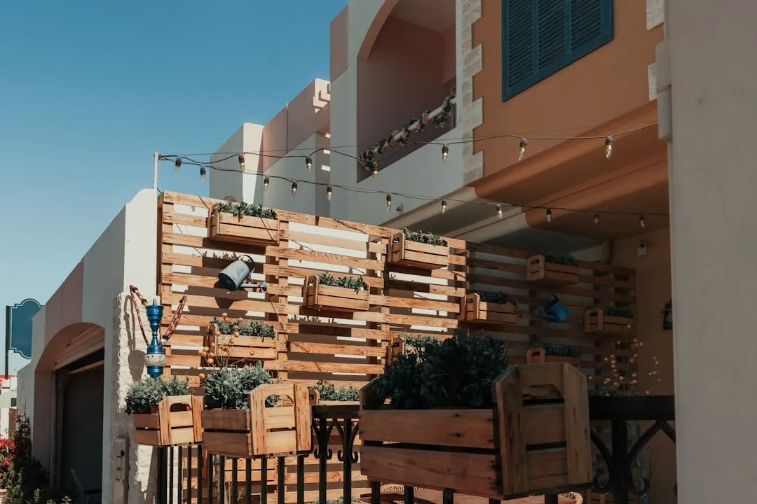 Mixed material outdoor privacy screening combining wood slats with metal frame detail