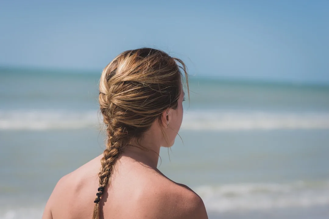Long sleek cornrow braids styled into a wrapped bun, protective style detail