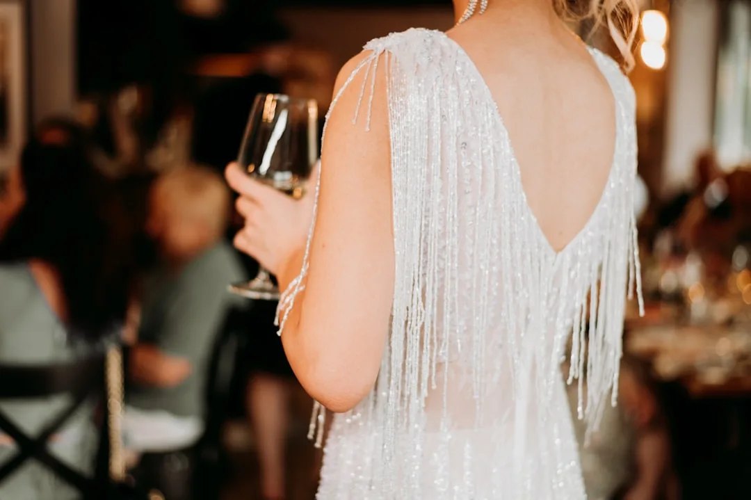 Bride wearing statement silk blouse and tailored trousers at rehearsal dinner