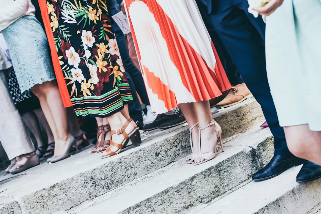 Close-up of monochromatic wedding guest outfit with textured fabrics and metallic accessories