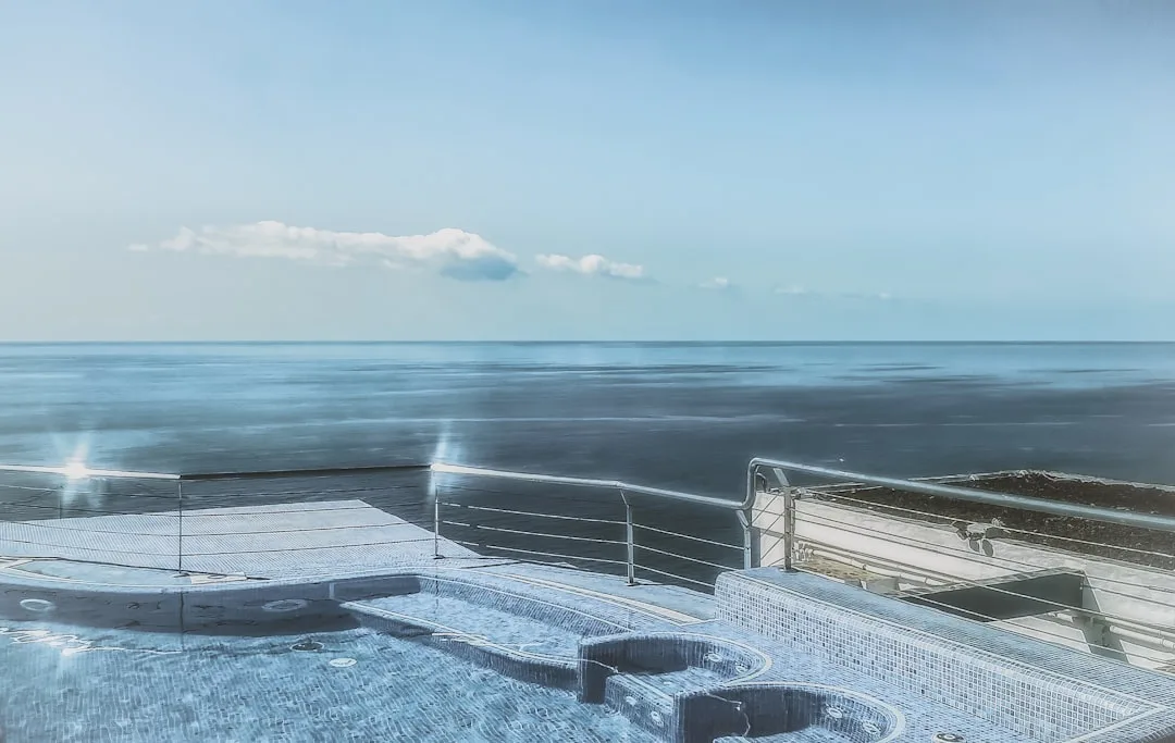 Luxury cruise ship amenities featuring infinity pool overlooking ocean waters detail 4