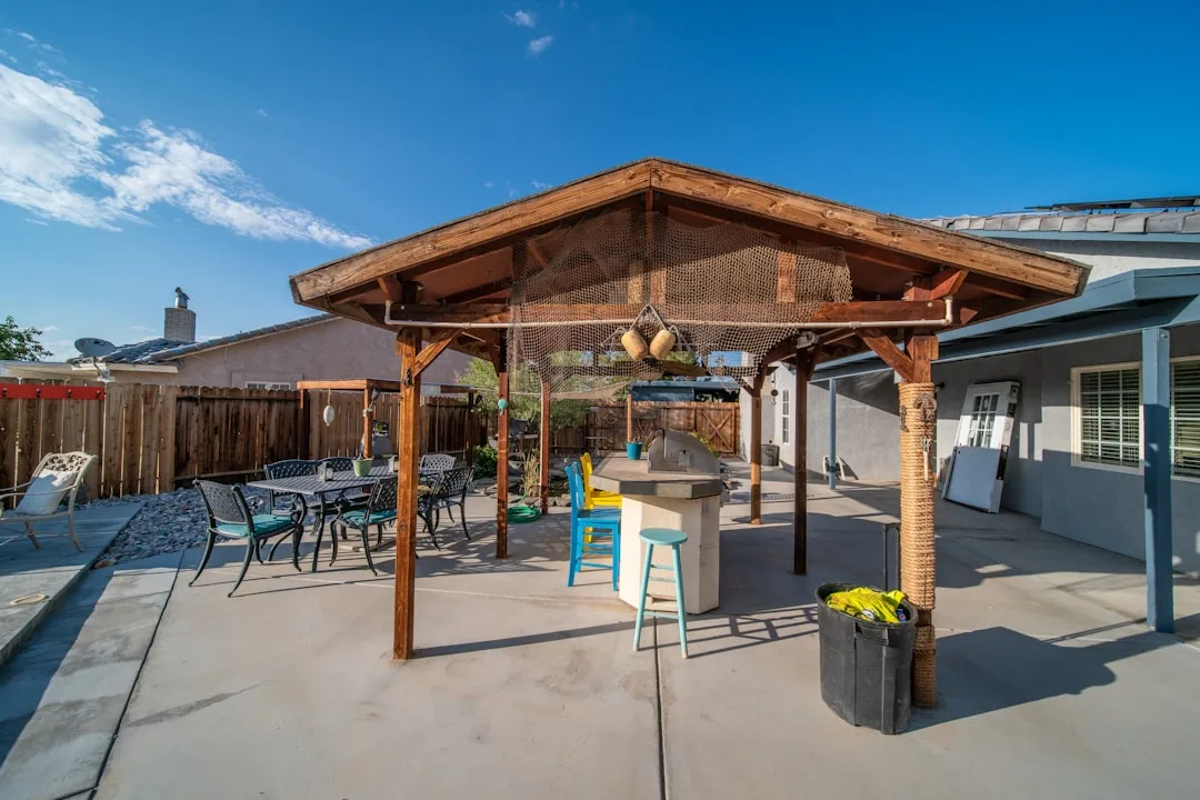Aluminum pavilion structure in residential backyard with shade cloth