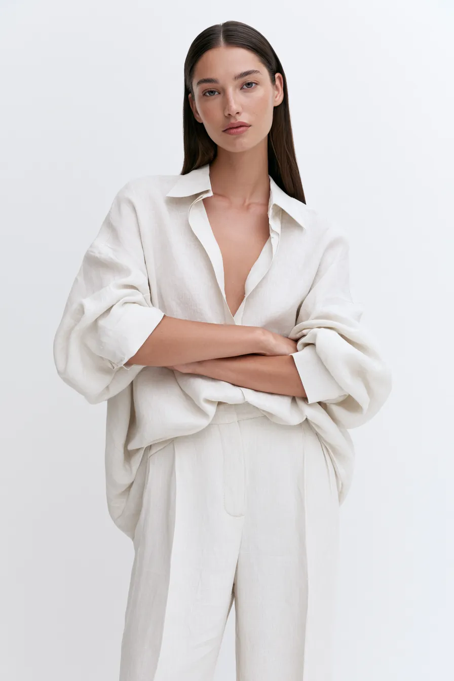 Minimalist style outfit with oversized linen shirt and straight-leg trousers in studio light