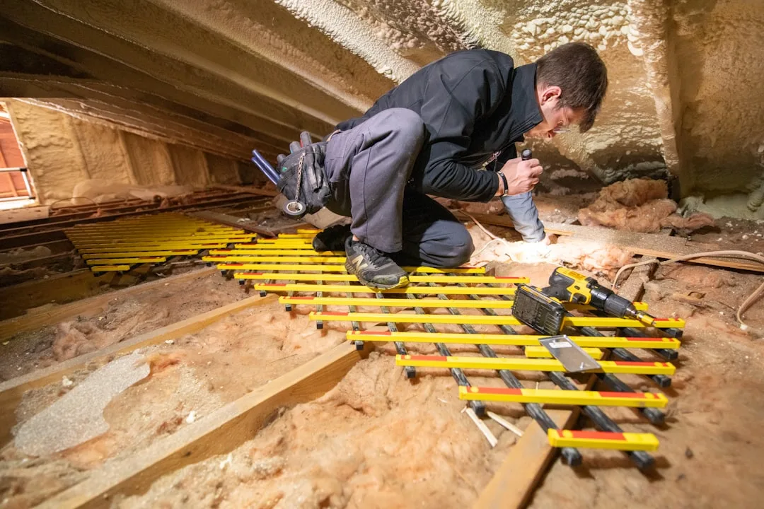 Cellulose attic insulation being blown into roof cavity with professional equipment