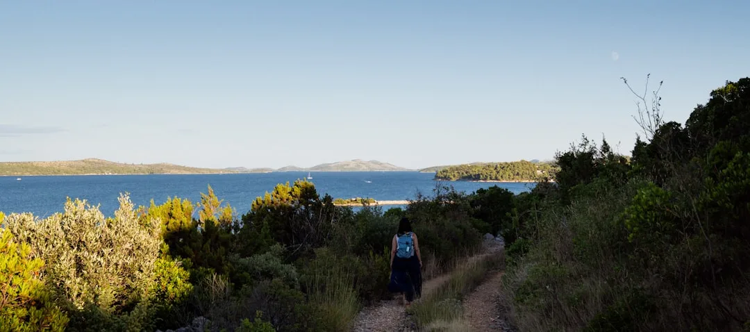 Woman performing Japanese walking interval training on outdoor trail with natural landscape detail 1