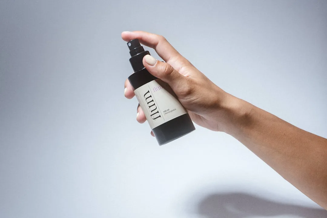 Woman applying hydrating face mist spray over makeup for skin hydration detail 3