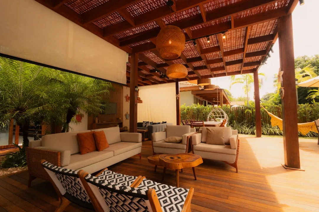 Motorized fabric shade sail system deployed over wooden deck seating area