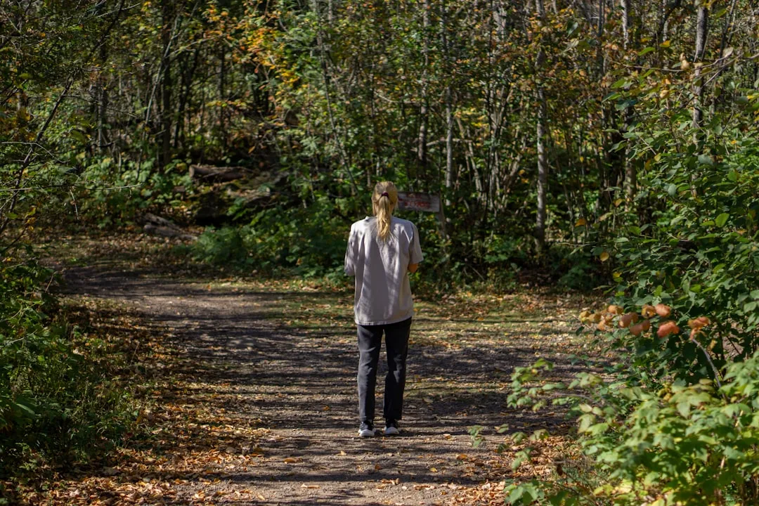 Woman performing Japanese walking interval training on outdoor trail with natural landscape detail 3
