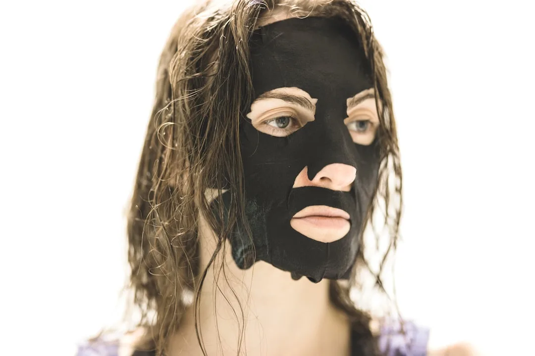 Dermatologist applying green clay texture refinement mask to client skin