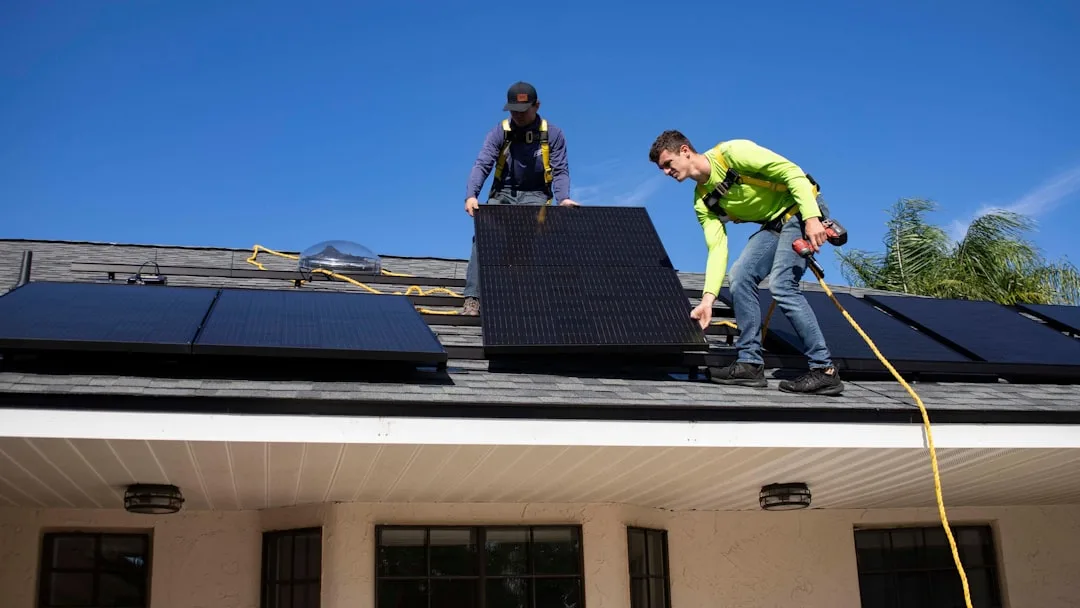 Solar panel installation on residential roof with blue sky background