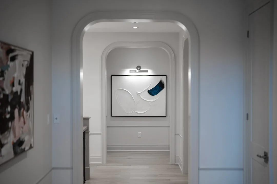 Curved doorway with white plaster walls and wood flooring detail
