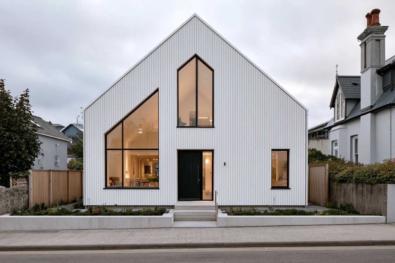 Scandinavian style house exterior with white timber cladding, large windows, and black steel door