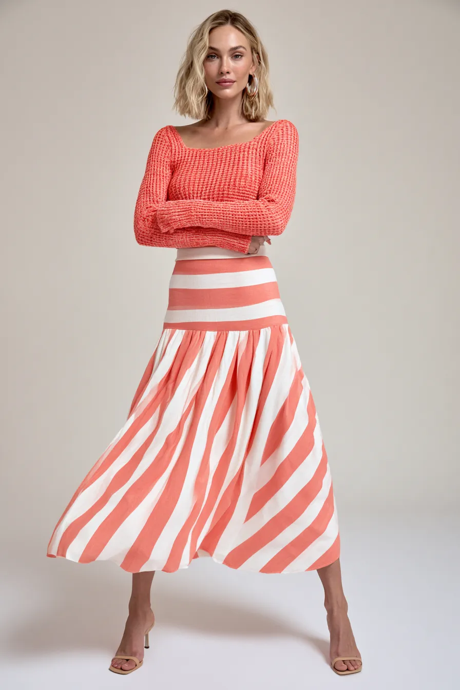 Studio fashion photo of a woman wearing a relaxed casual outfit with a midi skirt, editorial lighting