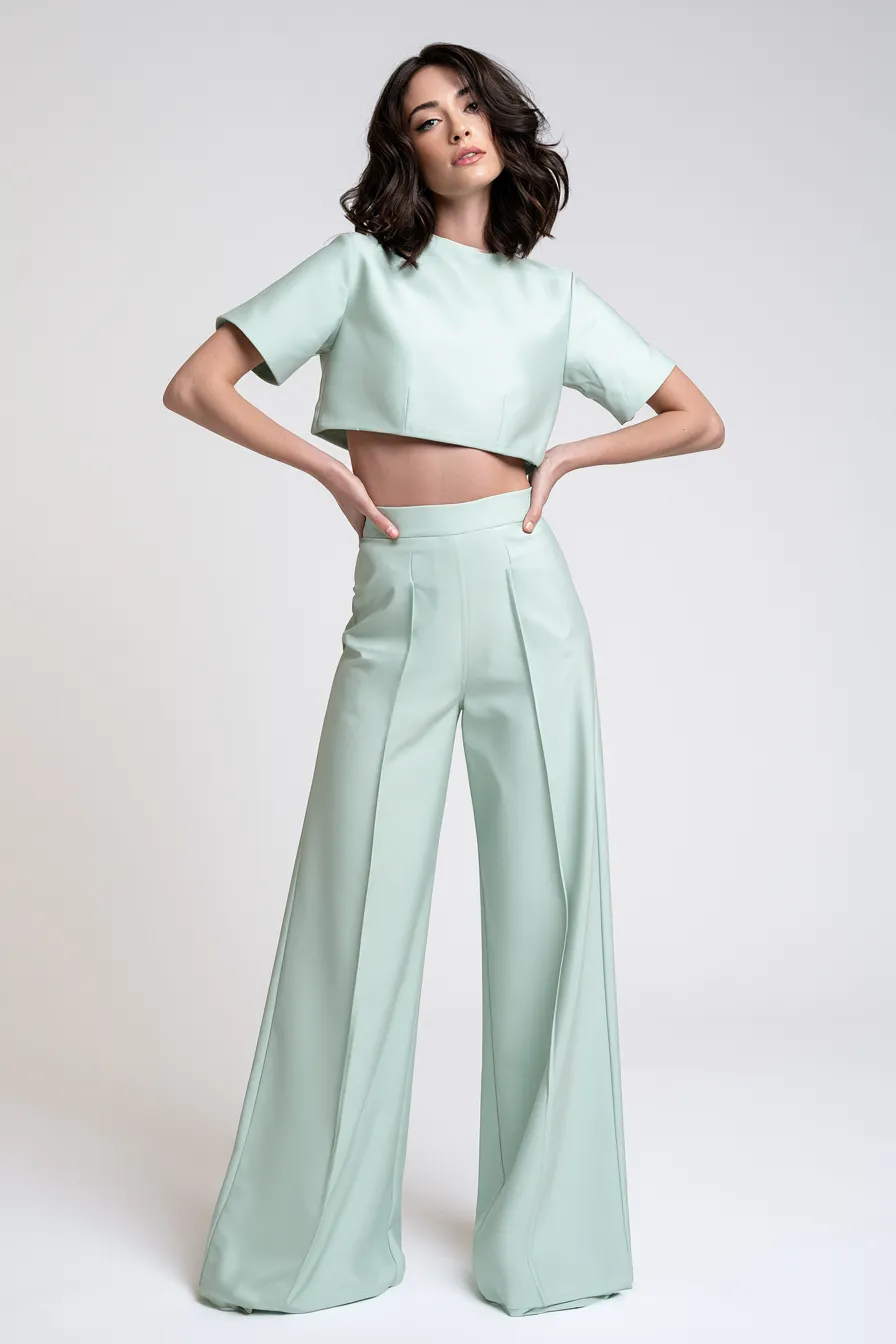 Studio editorial of trendy pastel green outfit on standing fashion model