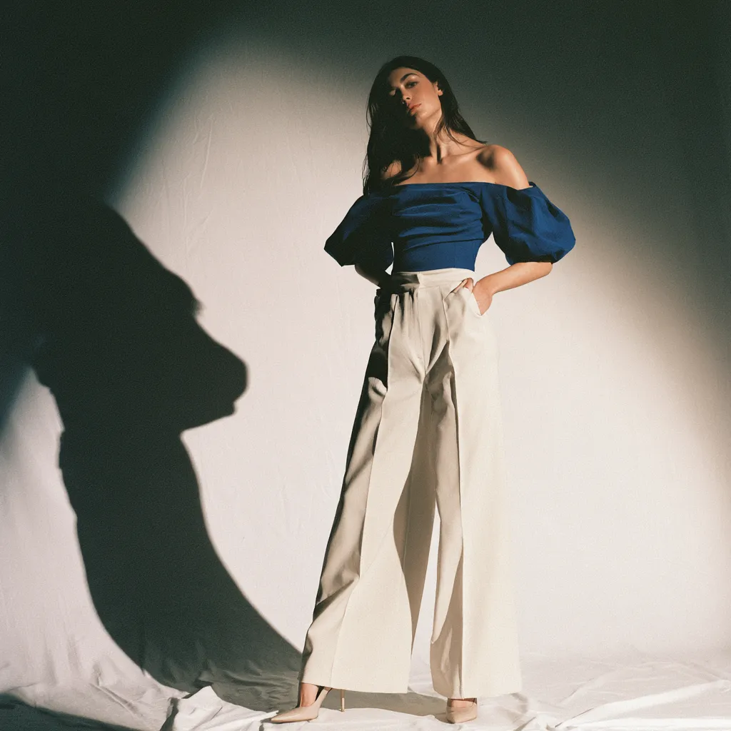 flattering pear shaped body outfit cobalt blue top cream wide leg trousers standing