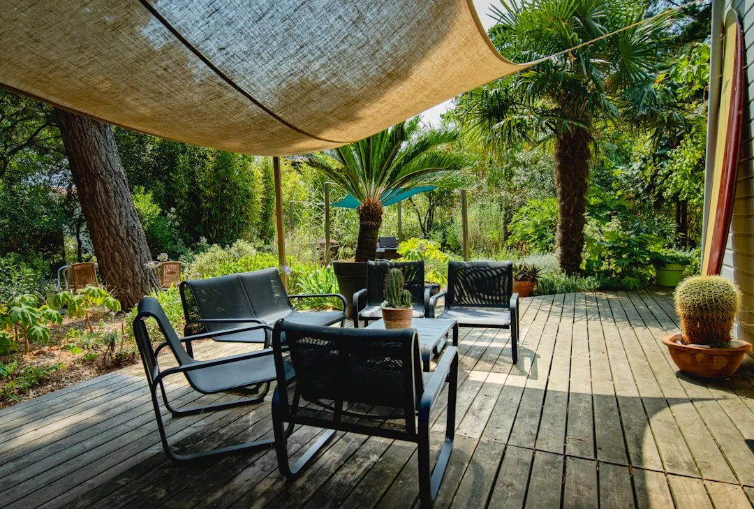 Curved shade sail installation over outdoor seating area with lounge furniture