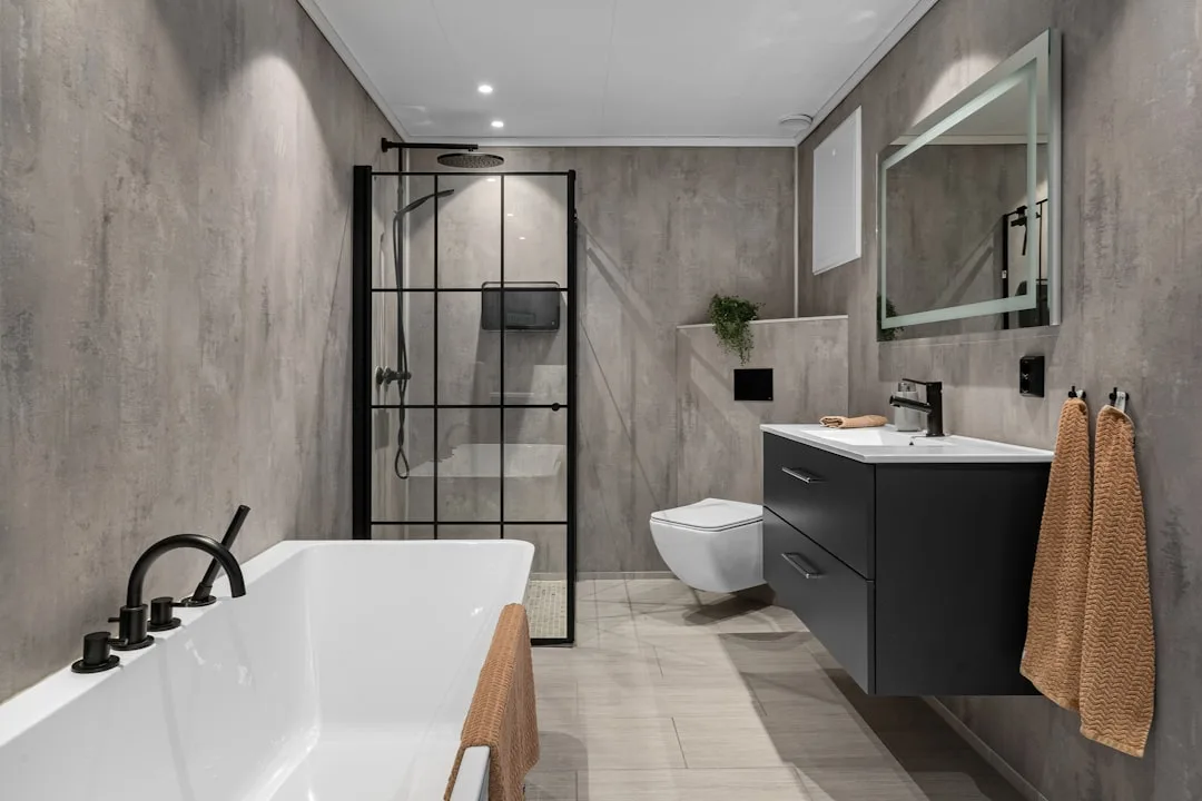 Textured bathroom walls with stone finish and brass fixtures creating depth