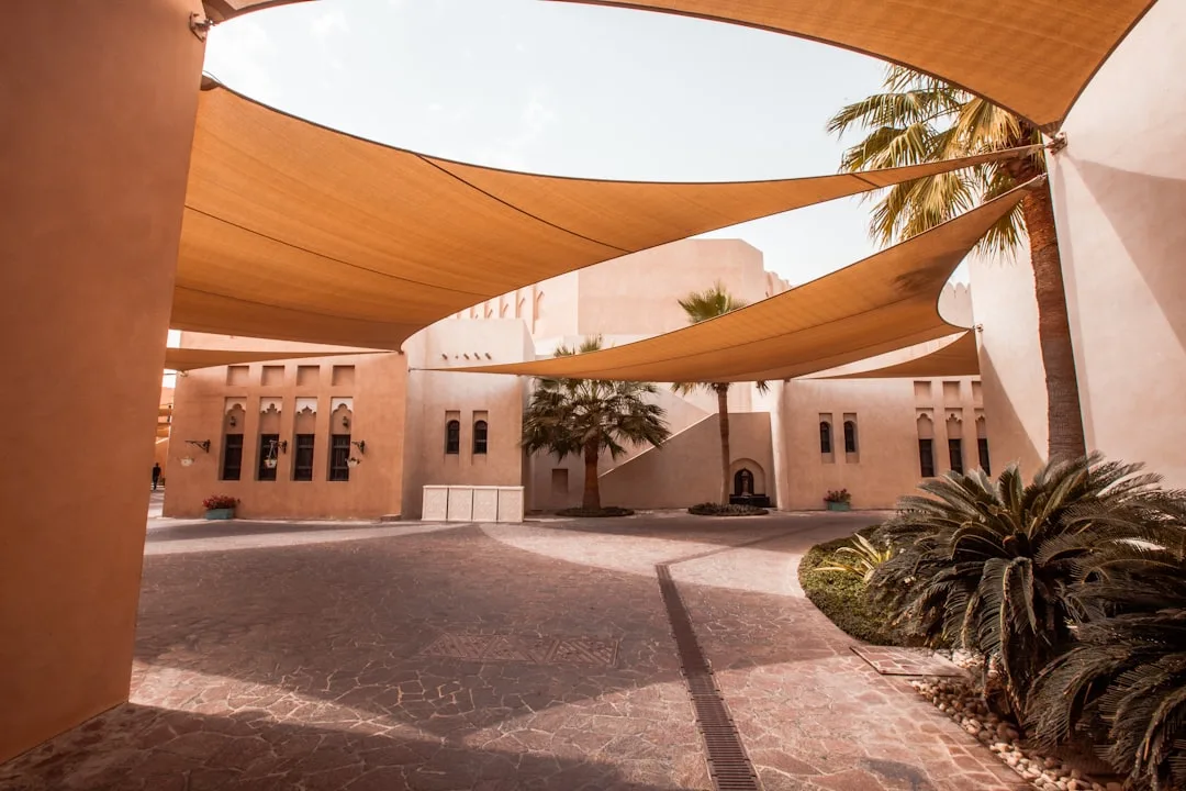 Multiple overlapping shade sails creating geometric shadows on residential patio deck