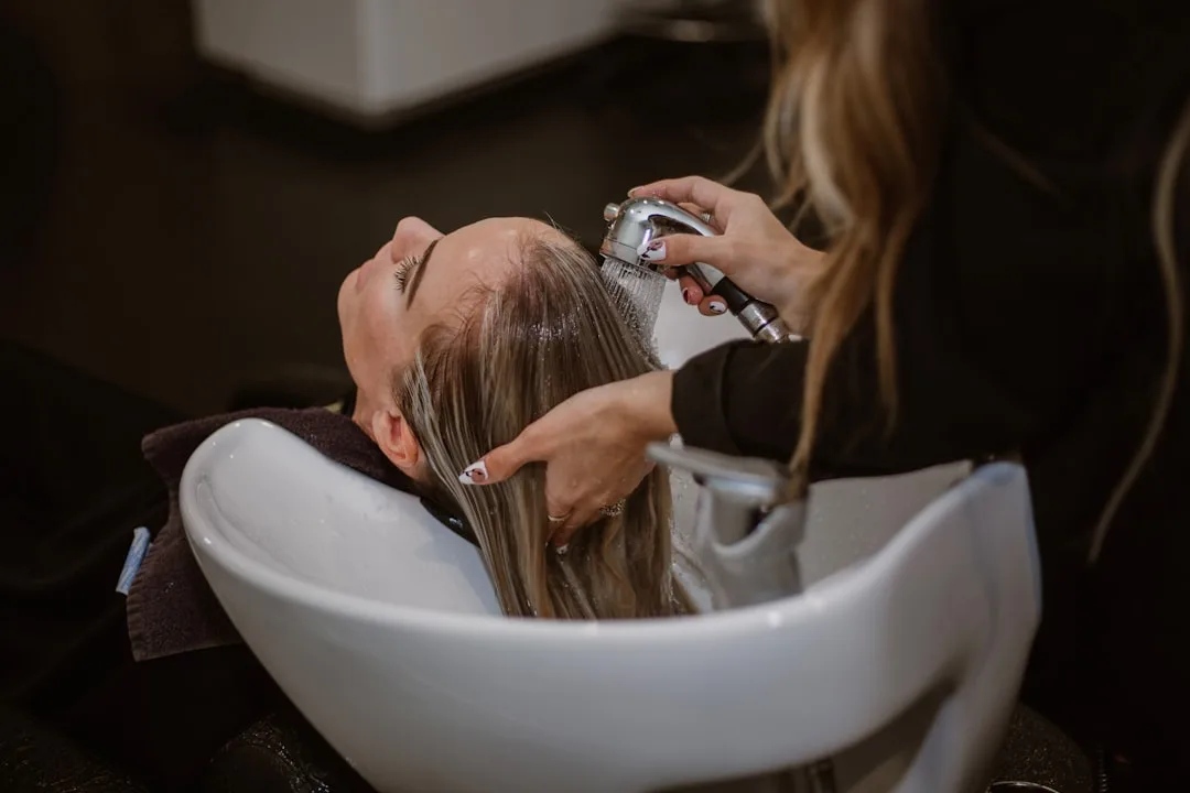Woman applying scalp care exfoliant massage treatment with fingers