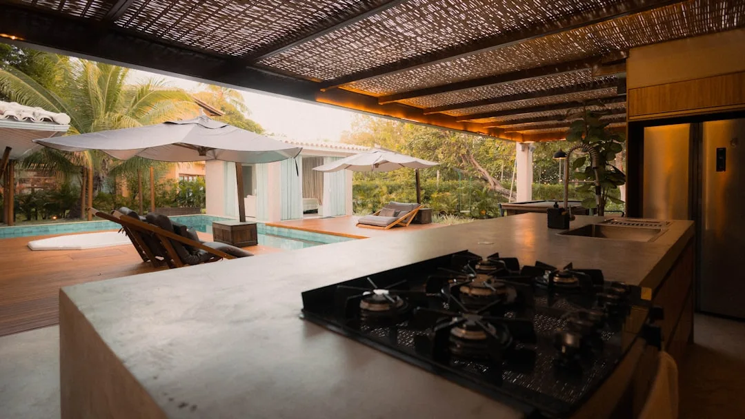 Professional-grade outdoor grill and burner appliances integrated into concrete patio kitchen