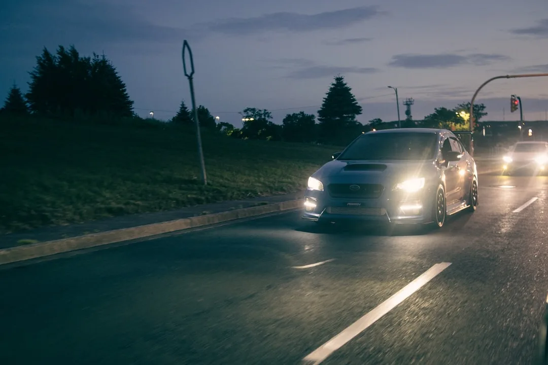 Comparison of standard vs adaptive headlight beam patterns on dark highway
