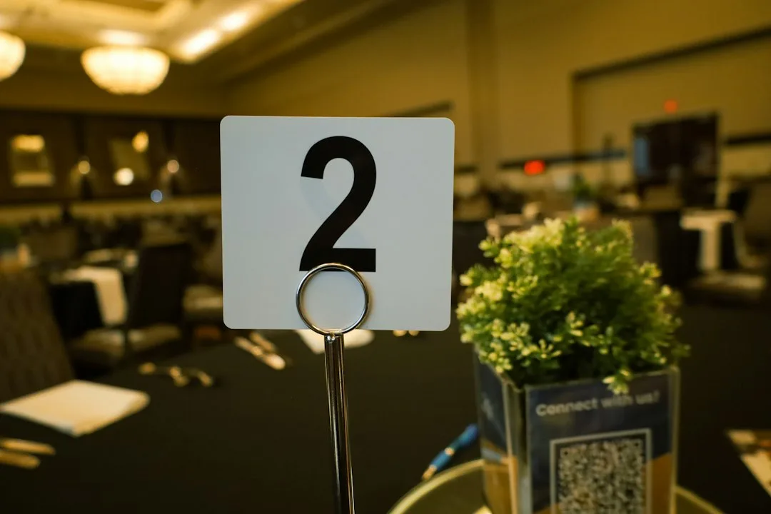 Silent auction event with bidders reviewing artwork and placing bids on paddle