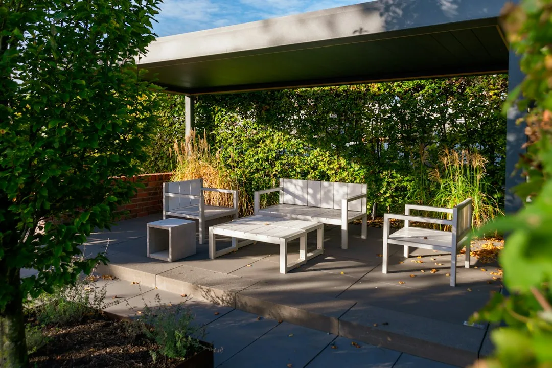 Patio microclimate design with layered shade structures and thermal mass elements