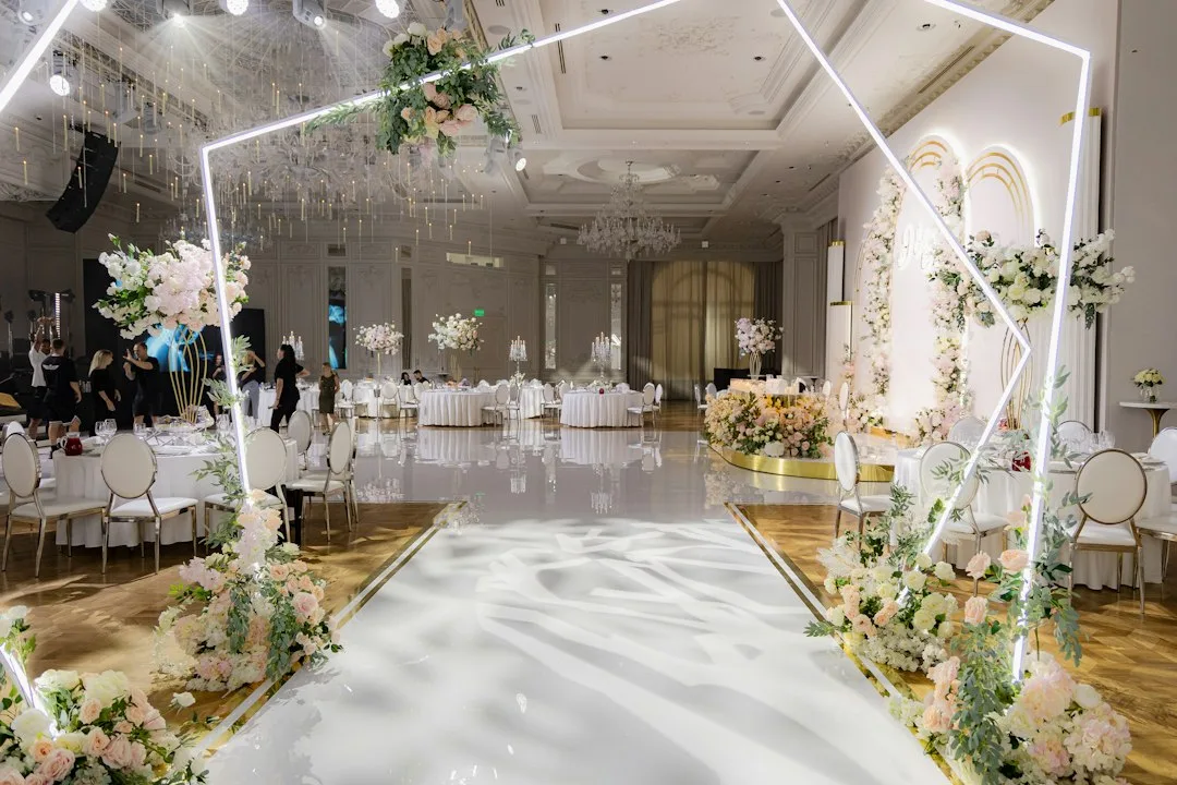 Minimalist wedding backdrop with natural wood arches and soft lighting design
