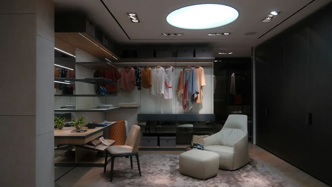 White lacquered walk-in closet island with drawer dividers and lighting