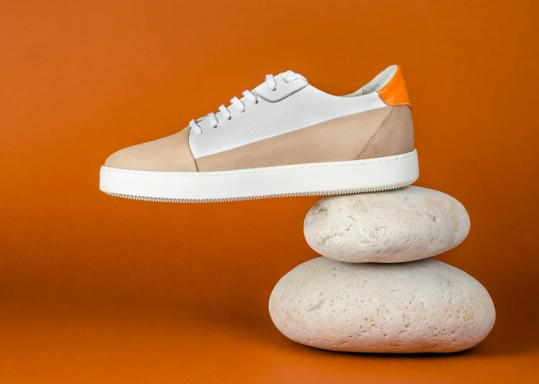 Close-up of taupe leather minimalist shoe showing clean seams and architectural heel