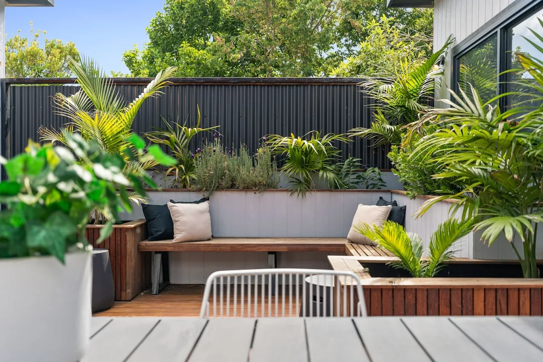 Modular wooden outdoor bench seating arrangement configured in L-shape around fire pit area