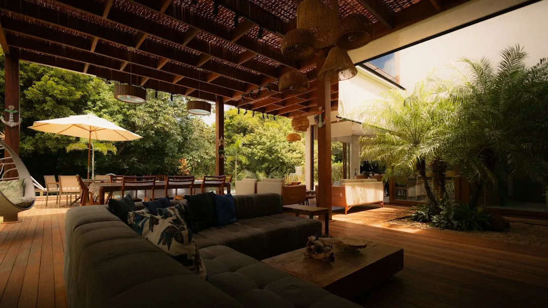 Patio microclimate design showing wind barrier plants and reflective surface materials