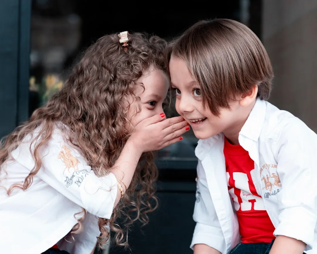 Two children sitting and talking through a disagreement together peacefully
