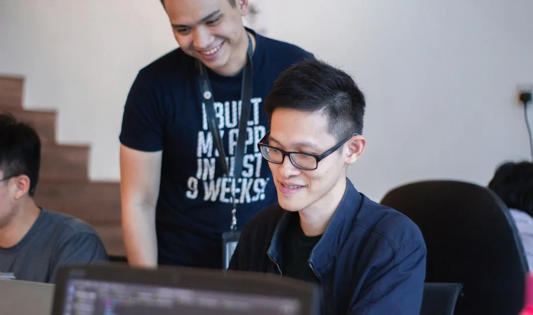 Live coding bootcamp mentor teaching developer at desk with code displayed