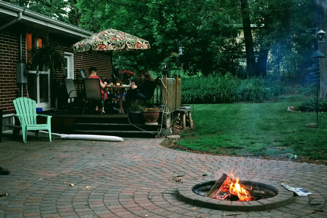 Outdoor fire pit seating area with curved benches and ambient lighting