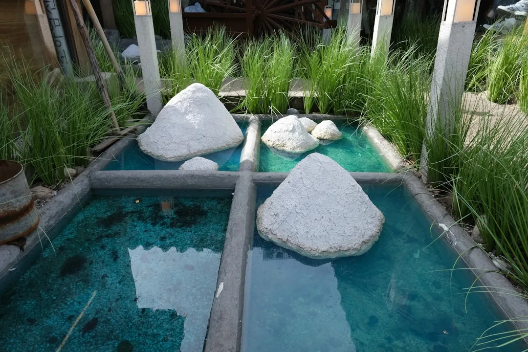 Raised outdoor pond basin integrated into modern patio flooring near seating area